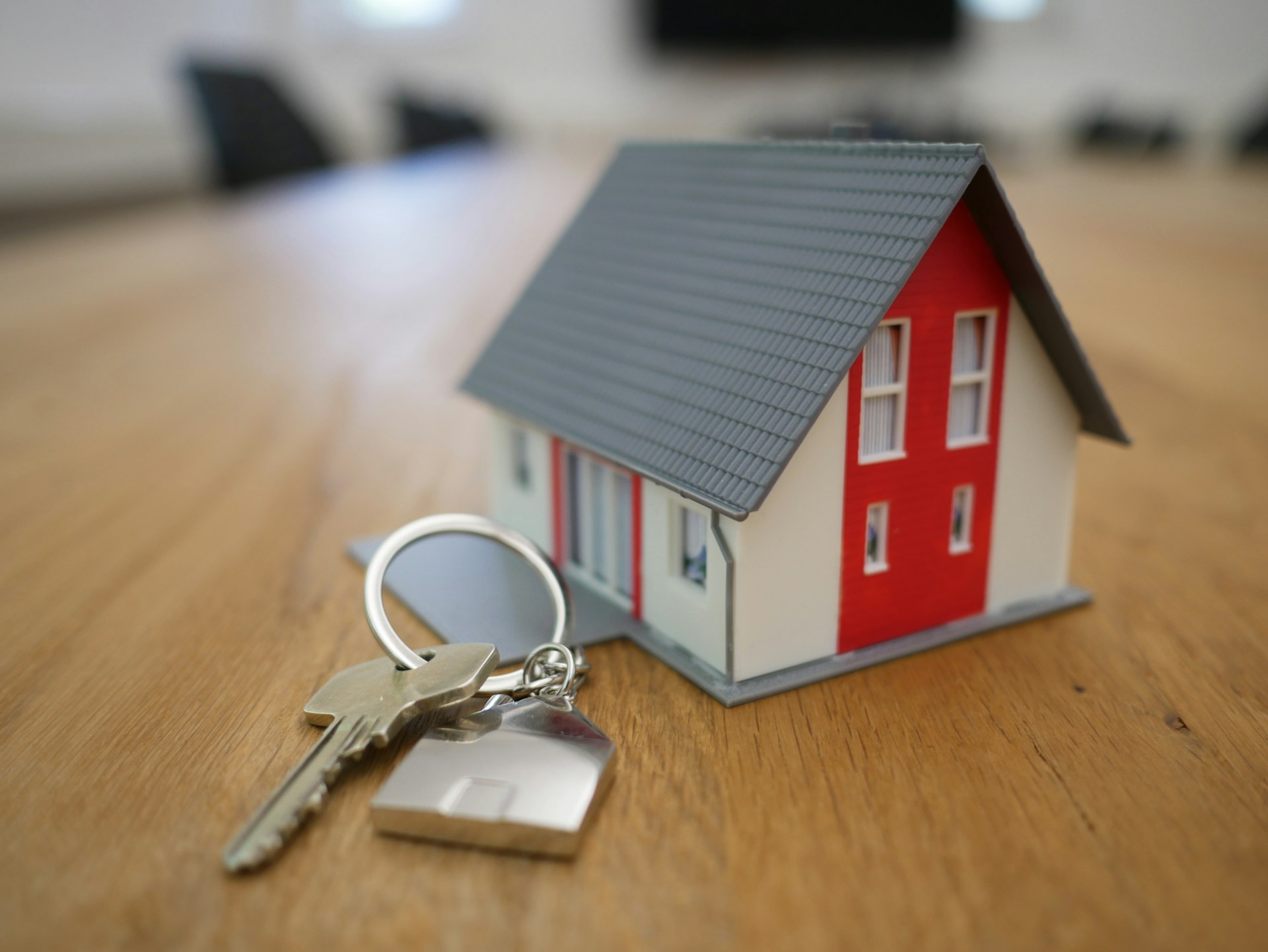 Chave dourada e miniatura de casa — registro de imóveis em Sinop